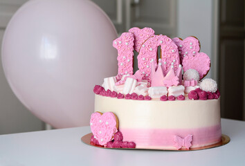 Pink and white cake with number 10 and hearts on the table with balloons. Birthday, anniversary.