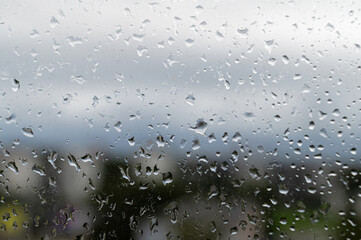 raindrops on window glass, selective focus, rainy city background, wet glass, texture of raindrops