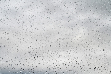 raindrops on window glass, selective focus, rainy city background, wet glass, texture of raindrops