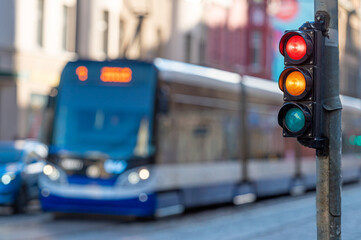 view of city traffic with traffic lights, in the foreground a semaphore with a red and orange light