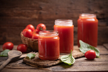 Tomato sauce in a glass jar on a rustic wooden table