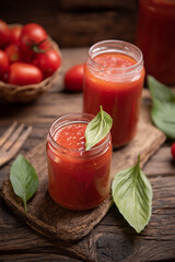 Fototapeta na wymiar Tomato sauce in a glass jar on a rustic wooden table