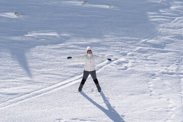 mujer joven pasando un dia en la montaña cubierta de nieve