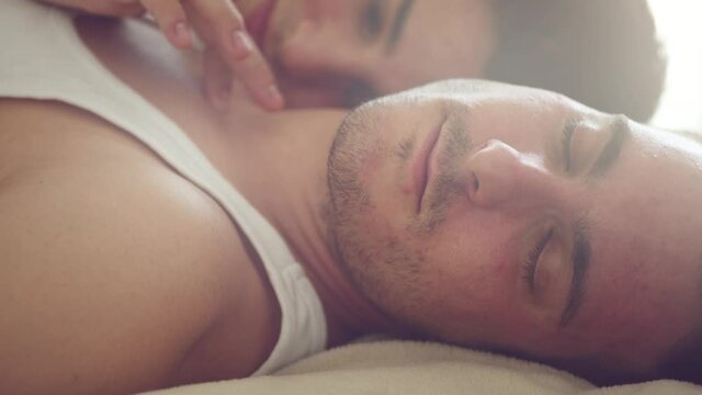 Romantic gay couple lying in bed, kissing and hugging. Men Couple in love. LGBT