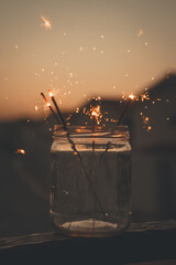 Fototapeta na wymiar Sparklers in a glass jar at sunset