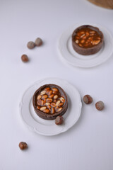 chocolate dessert with nuts standing on the white wooden table