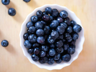 Delicious fresh blueberries in a white deep plate on the table