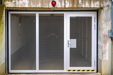 Einfahrt in eine Tiefgarage mit Kipptor mit integrierter Tür