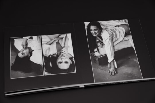 open photobook from a photo shoot of an attractive woman on a black background. 