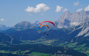 two friends paragliding in the Austrian Alps of the Schladming-Dachstein region (Austria)	