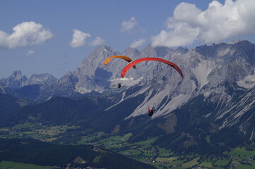 two friends paragliding in the Alps of the Schladming-Dachstein region in Austria	
