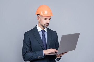 businessman man in building helmet using computer, safety online conference