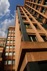 Looking up at the modern brown facade of  a typical corporate building from the 1980s. Genoa Madre di Dio district, Italy