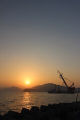 夕日と海に浮かぶ船のシルエット