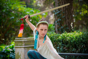 
Young woman practicing tai chi with a sword in an outdoor park