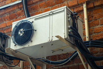 Conditioners on brick facade. Facade of house with cooling system. Block with fan from cooling...
