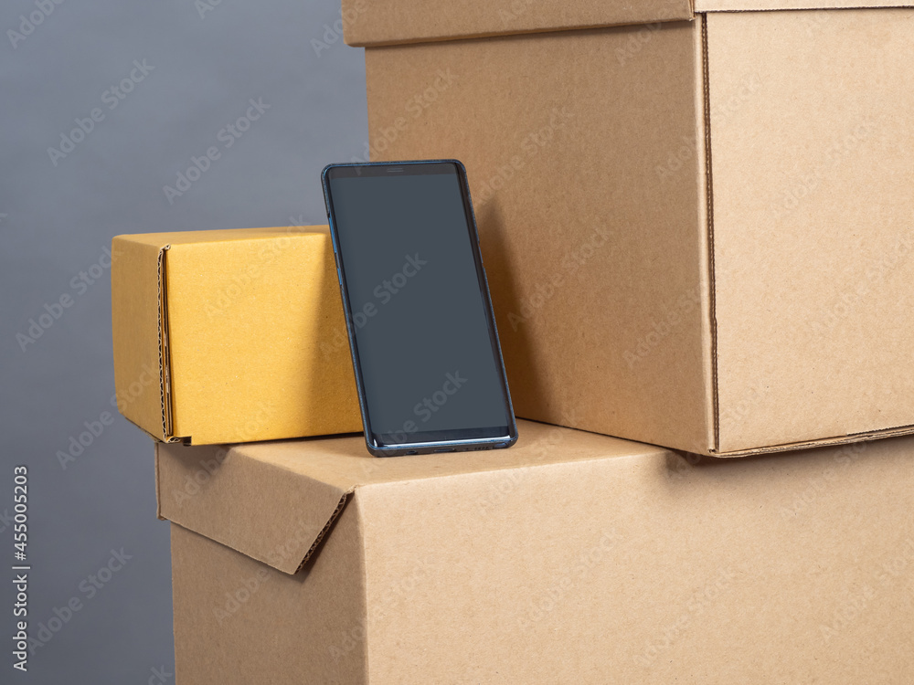 Poster phone on cardboard boxes. screen off phone. boxes as symbol of internet orders. ordering something v