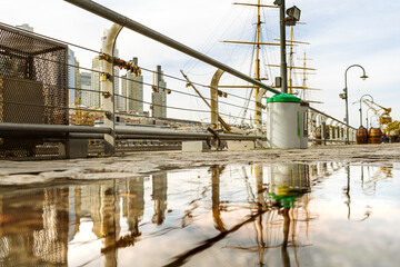 Reflections of buildings and other objects in the water surface of the street after a rain.