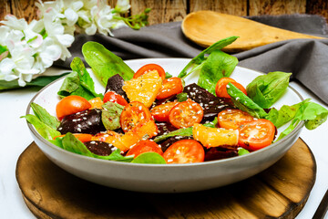 High view of exquisite salad of beetroot, orange, cherry tomato and arugula with olive oil