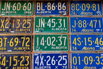 Vintage license plates affixed to a garage wall