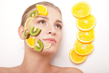 Smiling woman with fruit mask on her face isolated