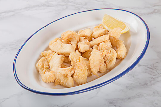 raci&oacute;n de chocos rebozados fritos con lim&oacute;n. tapas, tapas bar, casera, fritura andaluza, espa&ntilde;ola
