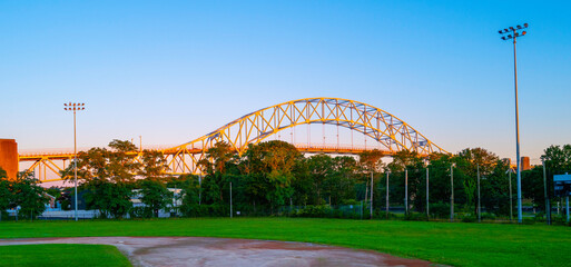 Youth baseball field with the view of the arched Sagamore Bridge illuminated by the rising sun
