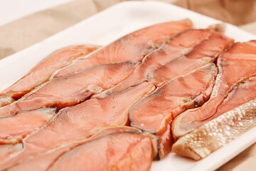 Red fish fillet meat close-up. Smoked trout or salmon, texture and macro photo. Content for an online store or advertising. Seafood close up