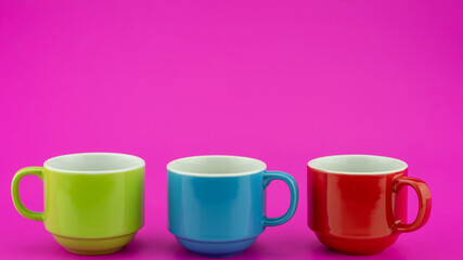 Colorful coffee cup on colorful paper background A lot of cups for coffee and tea in coffee shop Food and drink background concept