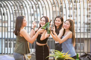 Group of women celebrating outdoors in hand holding beer bottles. merry bright smiley face sunset atmosphere.