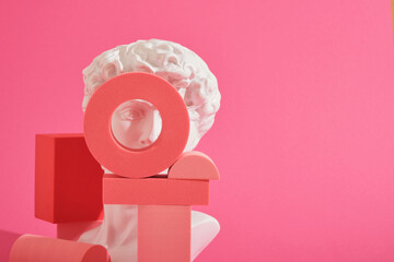 white decorative sculptural bust and several pink geometric coasters on a pink background
