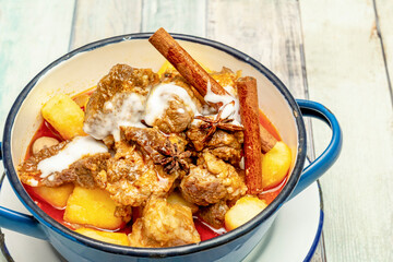 Delicious Thai sweet massaman beef curry in white and blue enameled metal bowl