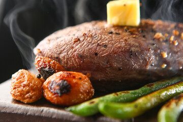Butter on beef that is cooking deliciously on a stone plate 돌판위에 먹음직스럽게 익어가고 있는 소고기 위 버터