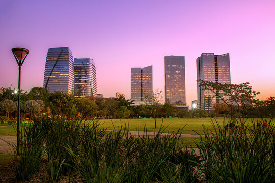 Atardecer com edificios comerciais em frente ao parque