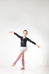 Portrait of a pretty little girl doing gymnastics over white background
