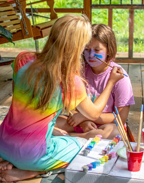 Girls painting faces on the porch