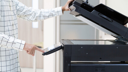Bussinessman press button on panel of printer photocopier  network , Working on photocopies in the...