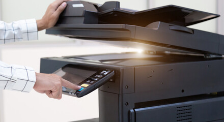 Bussinessman press button on panel of printer photocopier  network , Working on photocopies in the...