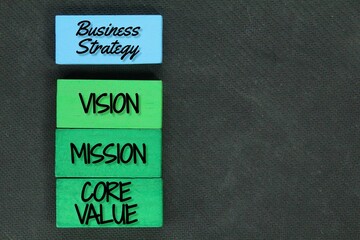a block of wood with the word for Business Strategy. Core values, vision and mission