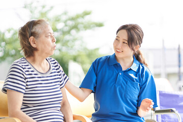 車椅子に乗る高齢者と女性介護士	
