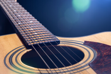 Acoustic guitar on a black background in the light of a spotlight.