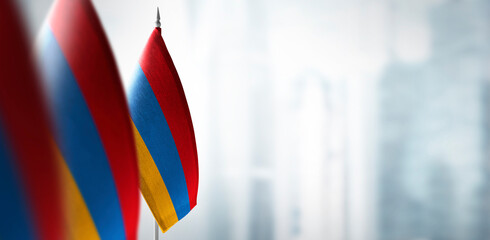 Small flags of Armenia on a blurry background of the city