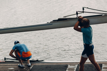 Sportsman single scull man rower carrying boat to competition © primipil