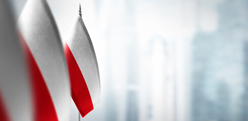 Small flags of Poland on a blurry background of the city