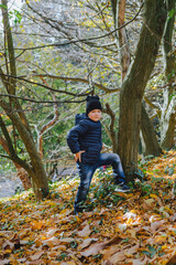 Naklejka premium little kid having fun in autumn park