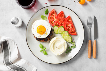 Juicy Chopped  steak with fried egg, mashed potatoes and tomato slices. top view