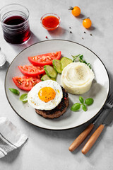 Juicy Chopped  steak with fried egg, mashed potatoes and tomato slices.