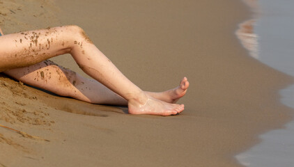 The girl in a swimsuit is lying on a lounger by the sea.