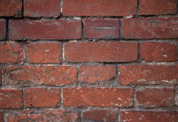 the texture of a red old brick wall with white scuffs and gray cement