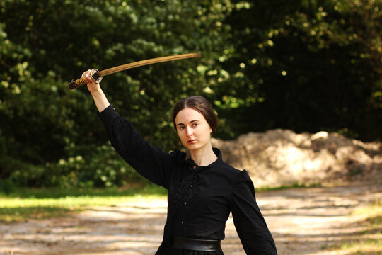 Woman with katana sword in the forest